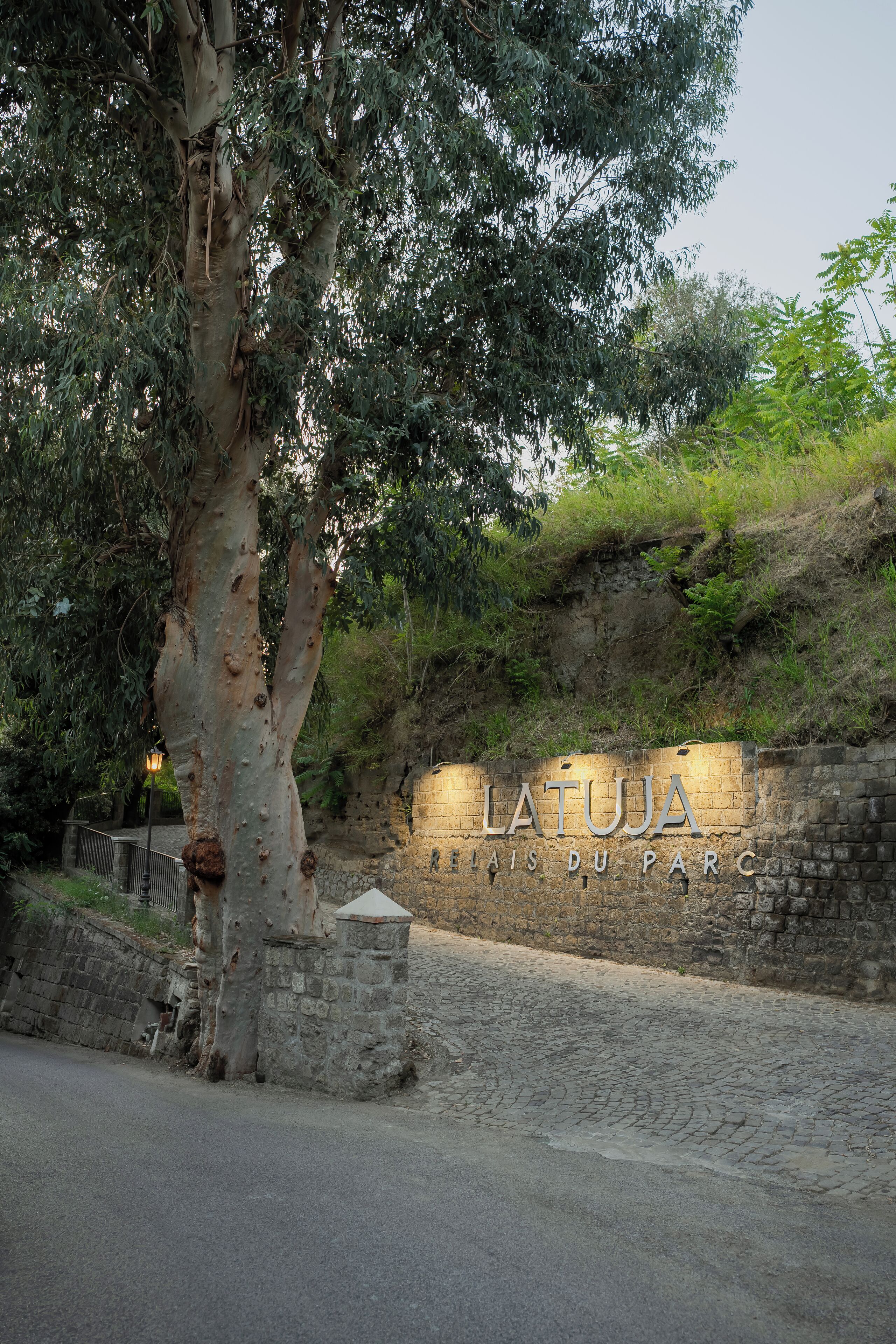 A stone wall with the inscription 'LATUJA' and 'RESTAURANT DU PARC' indicating a park restaurant.