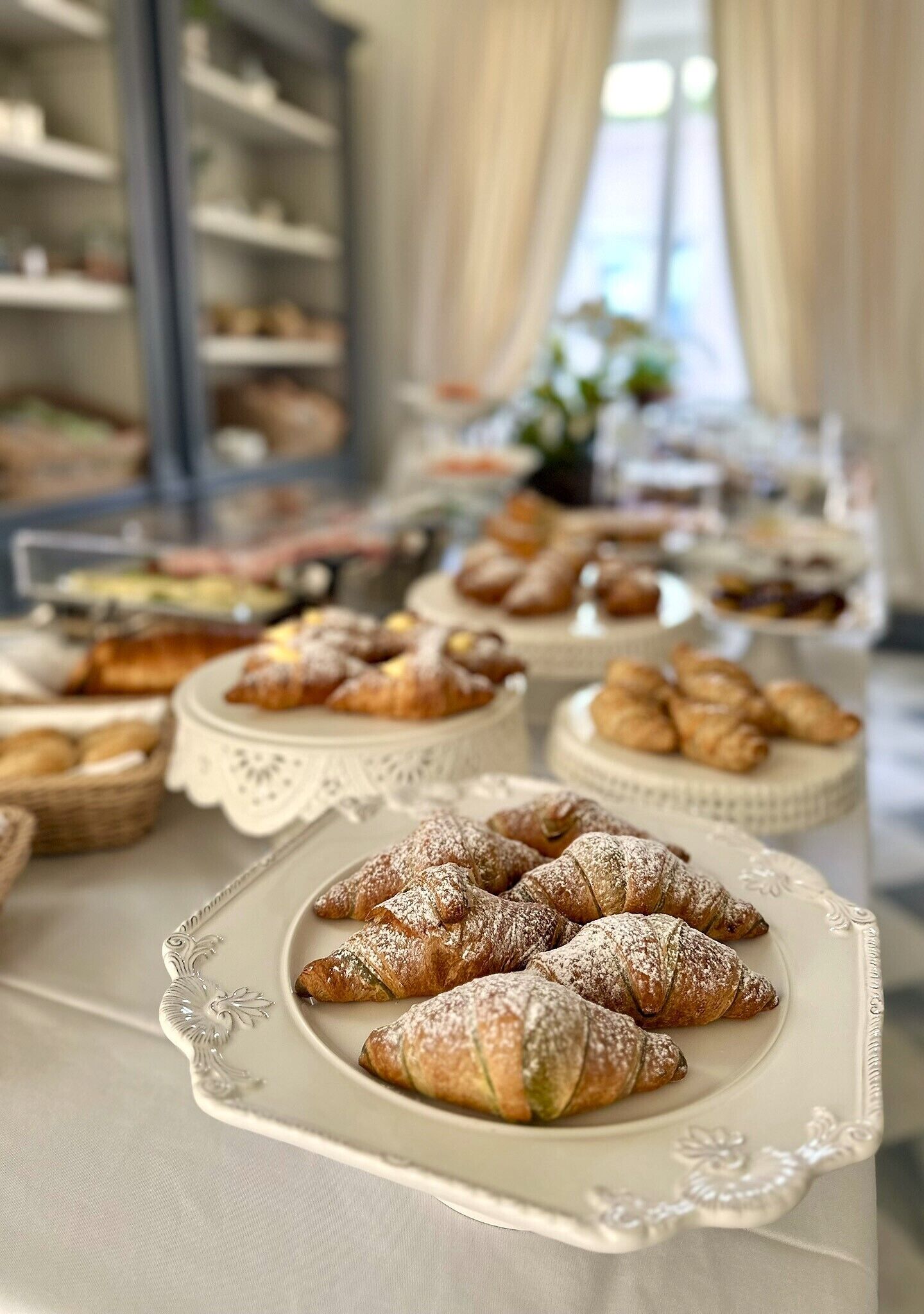 Une table de buffet proposant divers pâtisseries et desserts, notamment des croissants et du pain.