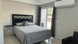 Une chambre moderne avec un lit, une chaise et un appareil de climatisation.