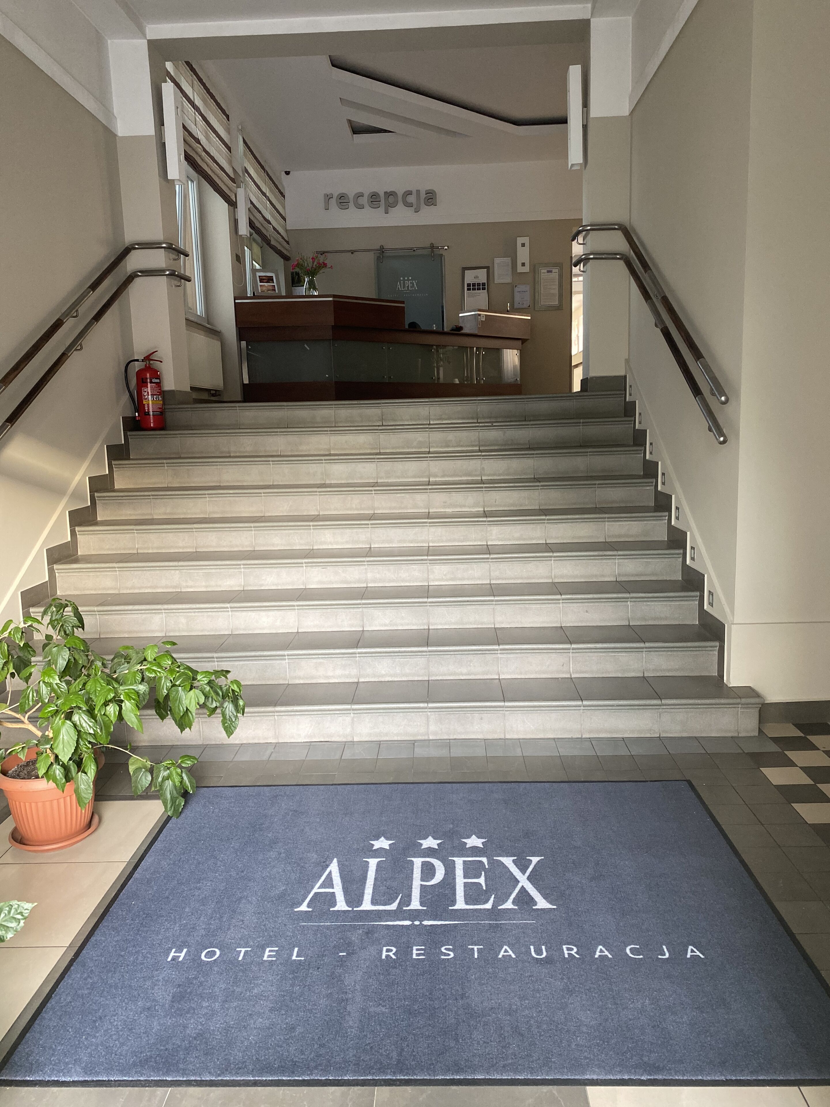 Ein Hotel-Empfangsbereich mit einer Treppe, die zu den oberen Stockwerken führt.