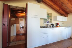 A modern kitchen with white cabinets, a stove, and a coffee maker. - Vacation Home in Cendon with 3 bedrooms sleeps 6 (Cendon)