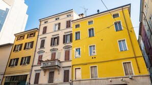A row of colorful buildings with a sign for 'OSTERIA del TEATRO' indicating a restaurant. - Comfortable 55 sqm apartment in the heart of Parma. The accommodation, which can host up to 4 guests, is located on the first floor of a period building without lift. Please note that there is one step to access the building and stairs to reach the apart (Parma)
