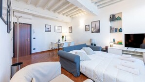 A hotel room with a bed, a desk, a chair, and a television. - Comfortable 55 sqm apartment in the heart of Parma. The accommodation, which can host up to 4 guests, is located on the first floor of a period building without lift. Please note that there is one step to access the building and stairs to reach the apart (Parma)