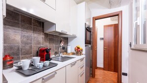 A modern kitchen with white cabinets, a built-in oven, and a coffee maker. - Comfortable 55 sqm apartment in the heart of Parma. The accommodation, which can host up to 4 guests, is located on the first floor of a period building without lift. Please note that there is one step to access the building and stairs to reach the apart (Parma)