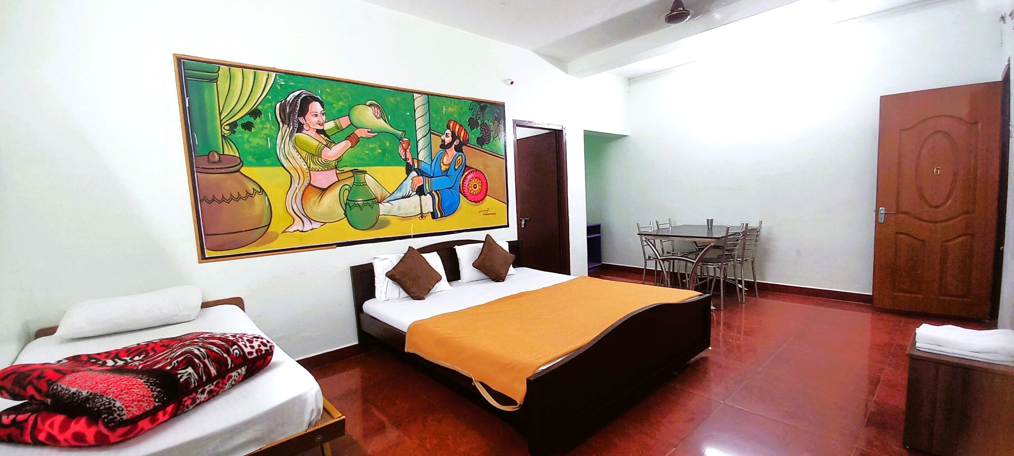 Una habitación de hotel con una cama, un cuadro, una mesa de comedor y un armario.