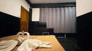 A hotel room with a bed, a TV, and a window with curtains. - Triple H Hotel  (Yangon)