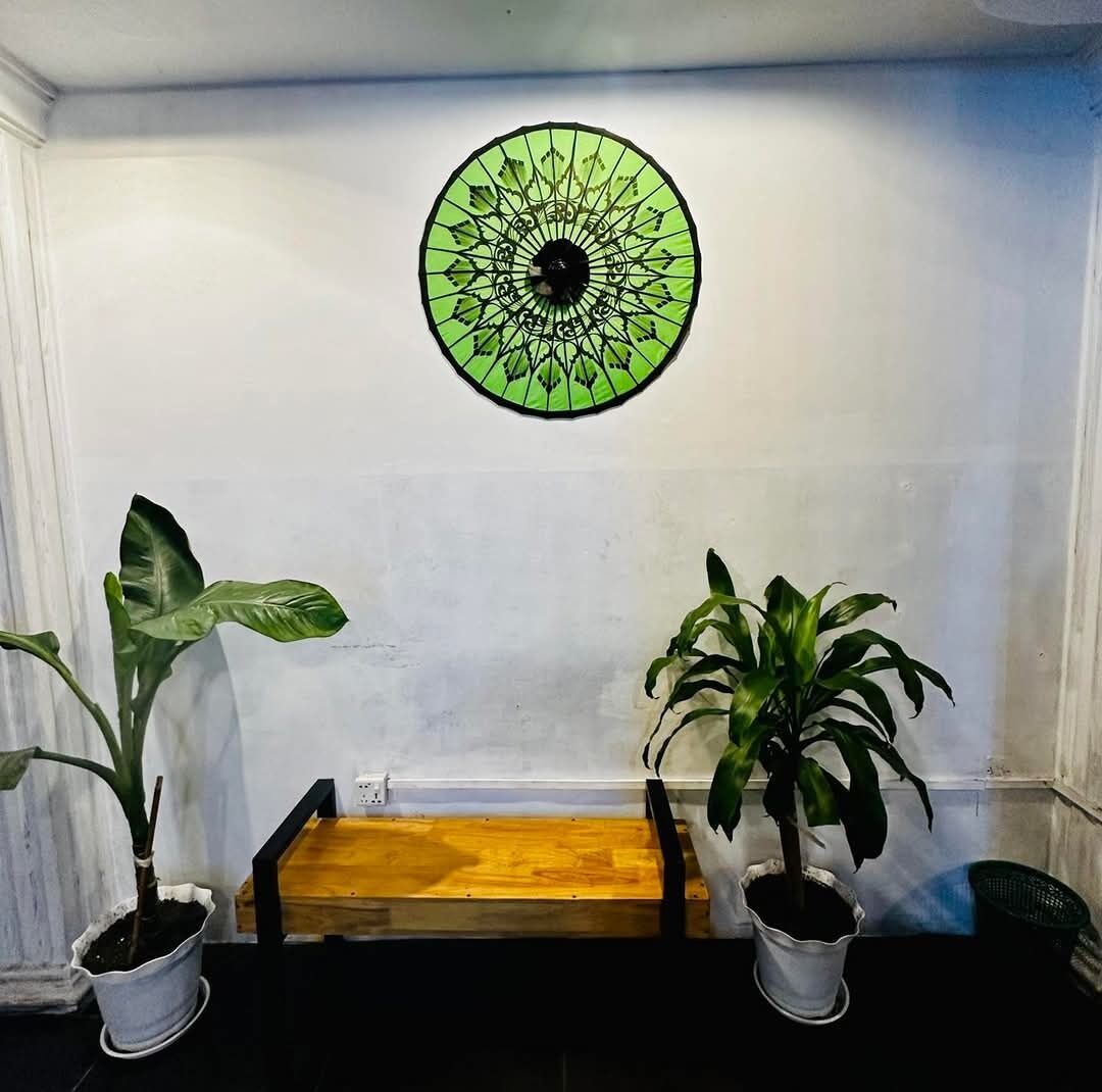 A room with a wooden bench, two potted plants, and a circular wall decoration.