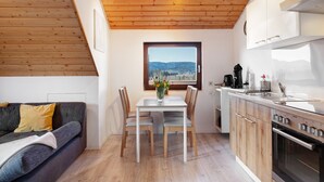 Une cuisine moderne avec des meubles en bois, une table à manger avec des chaises et une vue par la fenêtre.