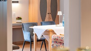 En matplats med ett bord, stolar, ett skåp och en lampa.