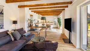 Una sala de estar moderna con un sofá, una mesa de centro y una televisión.