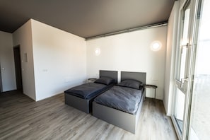 Een moderne slaapkamer met een bed, nachtkastjes en een raam.