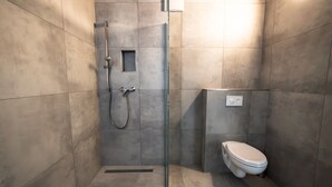 A modern bathroom with a glass shower enclosure, a toilet, and a control panel. - Room 'Zimmer 2' with Wi-Fi (Dußlingen)