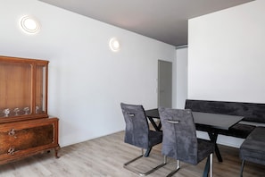 Un comedor con un aparador de madera, dos sillas, una mesa y un banco.