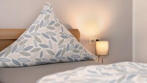 Ein Bett mit Kissen und einer Nachttischlampe.
