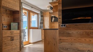 A wooden interior with a fireplace, wooden cabinets, and a view through a glass door.