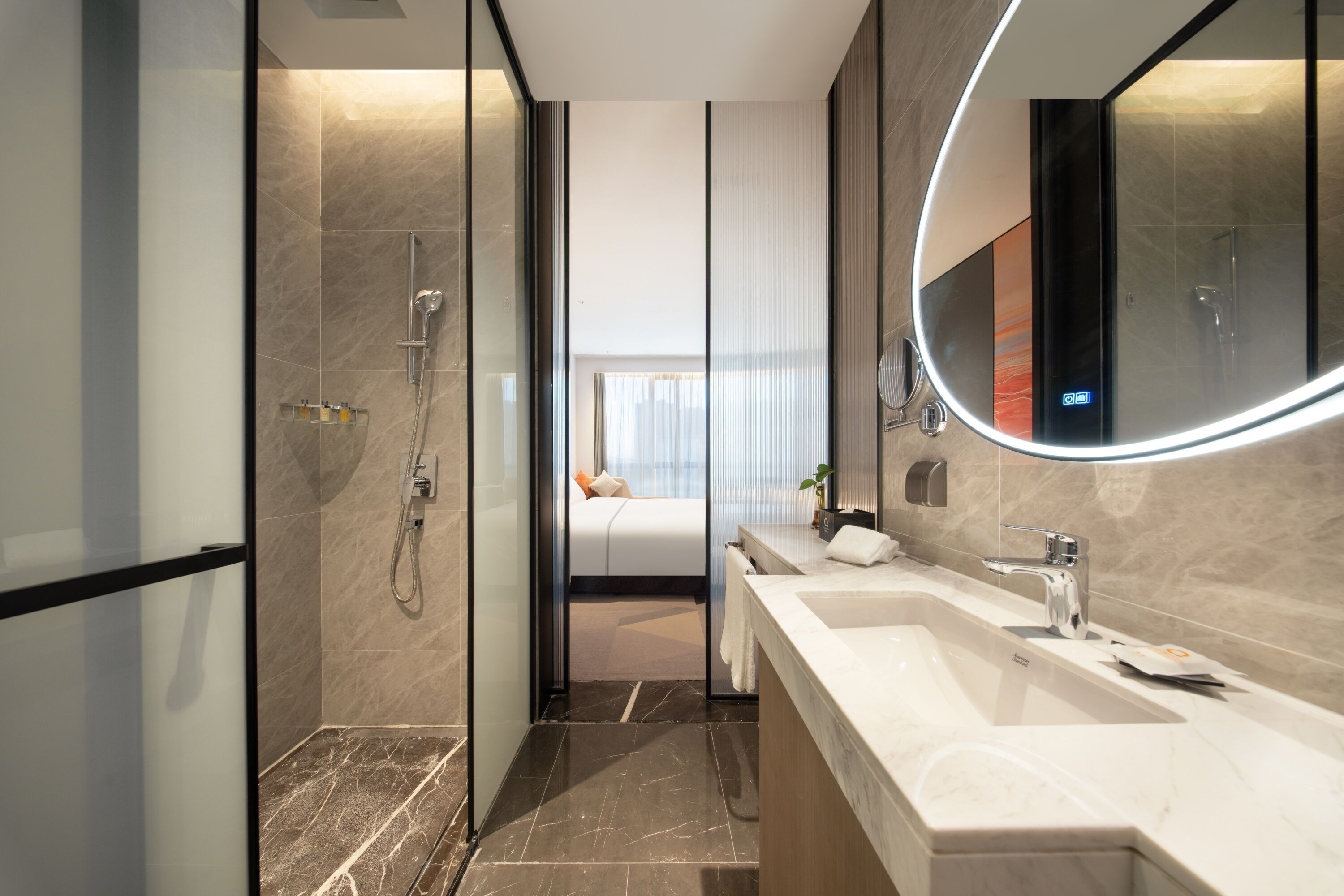 A modern bathroom with a glass shower enclosure, a large mirror, and a double sink vanity.