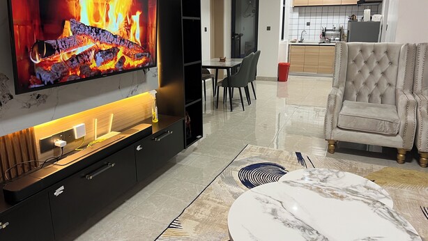 A modern living room with a flat-screen TV, a dining area, and a kitchen. - The loftel luxury  2-bedroom apartment with WiFi, AC in wonderful Nairobi (Nairobi)
