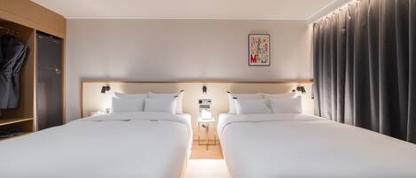 Una habitación de hotel con dos camas individuales, un armario, una mesita de noche y una obra de arte colgada en la pared.