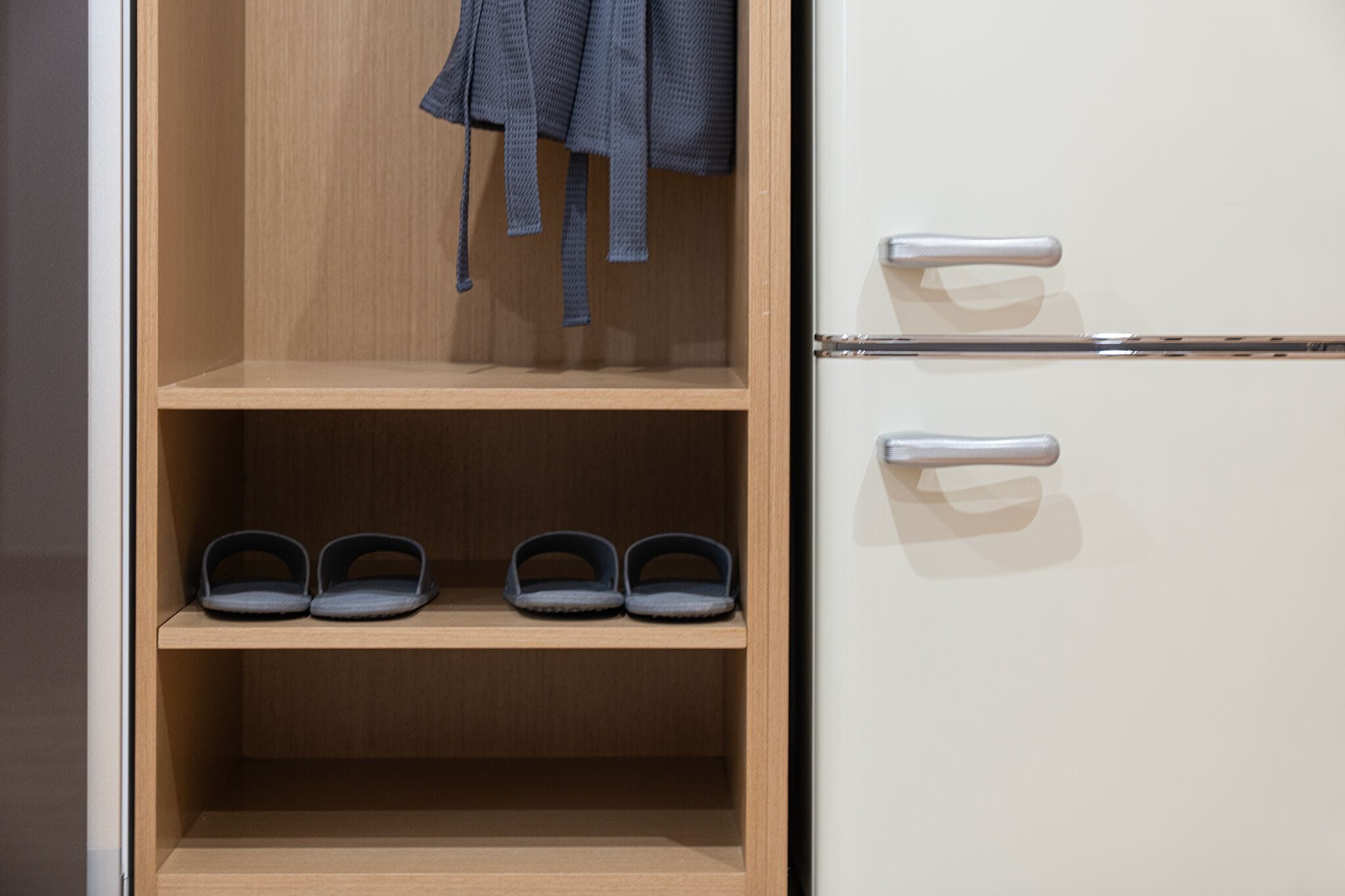 A wooden wardrobe with two drawers and a shelf.