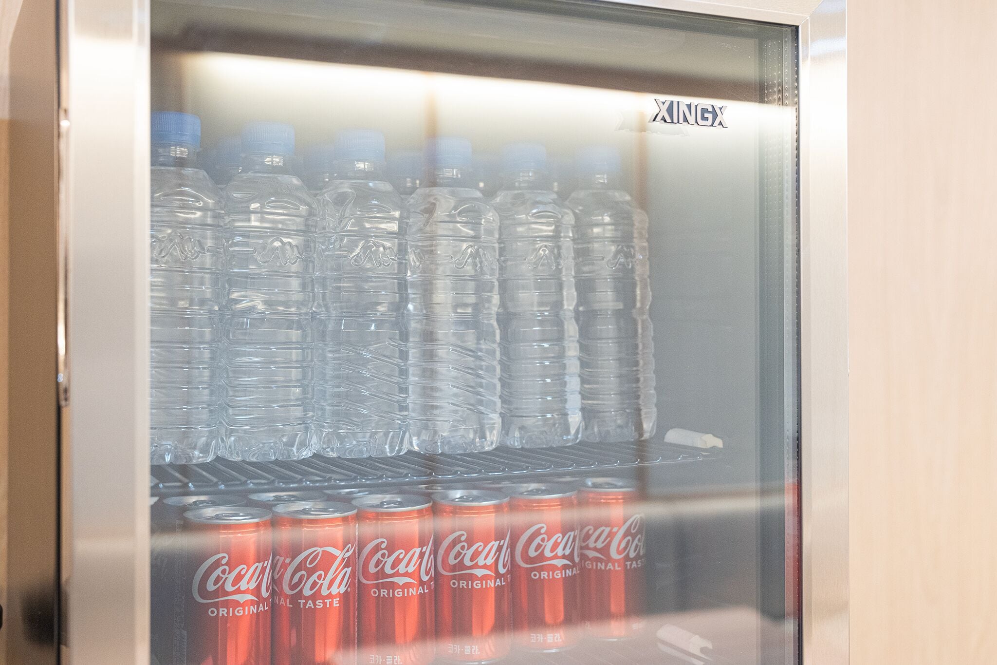 Máquina expendedora con botellas de agua y latas de Coca-Cola.