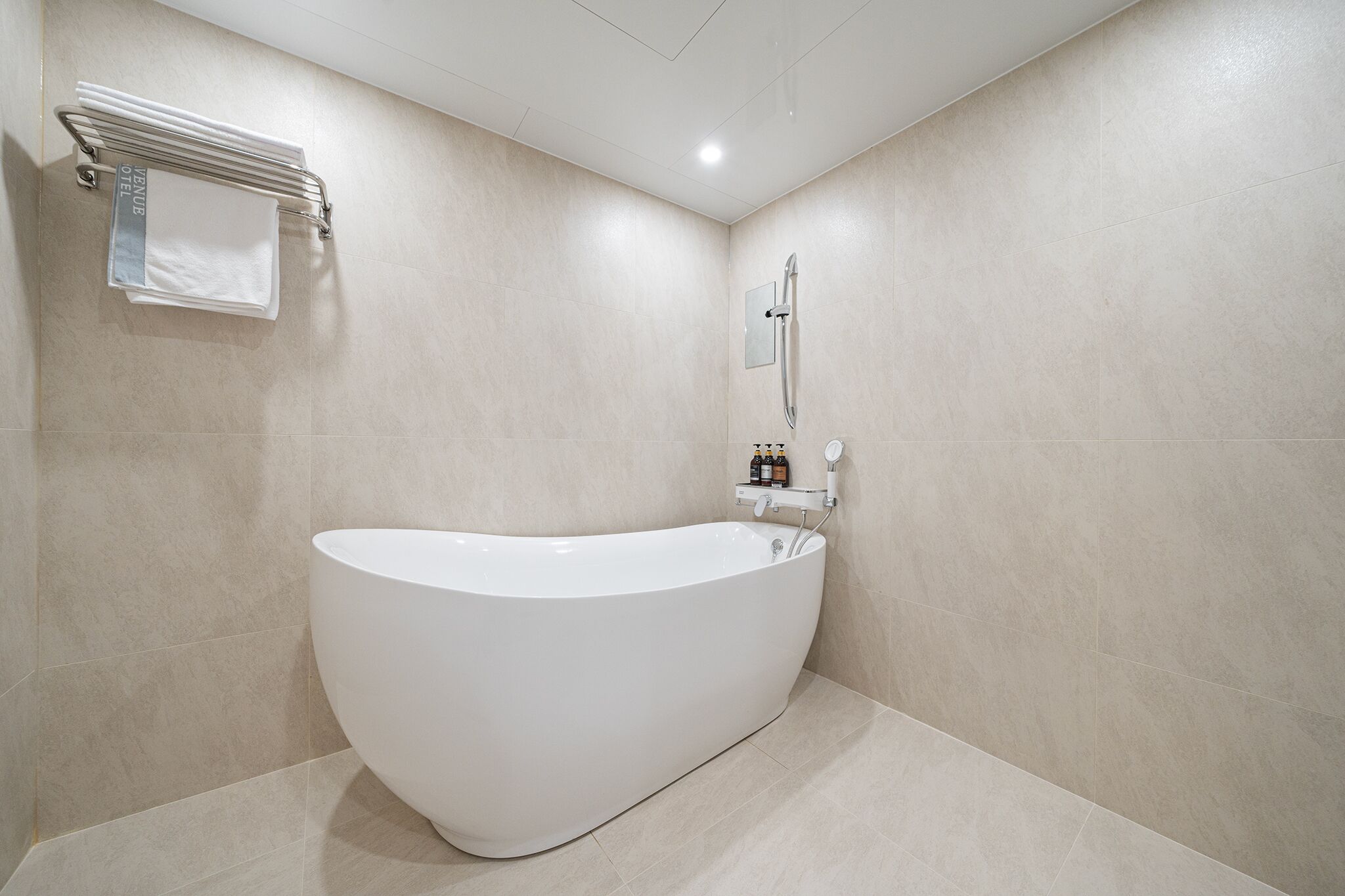 Ein modernes Badezimmer mit freistehender Badewanne, einem Handtuchhalter und einem Spiegel.