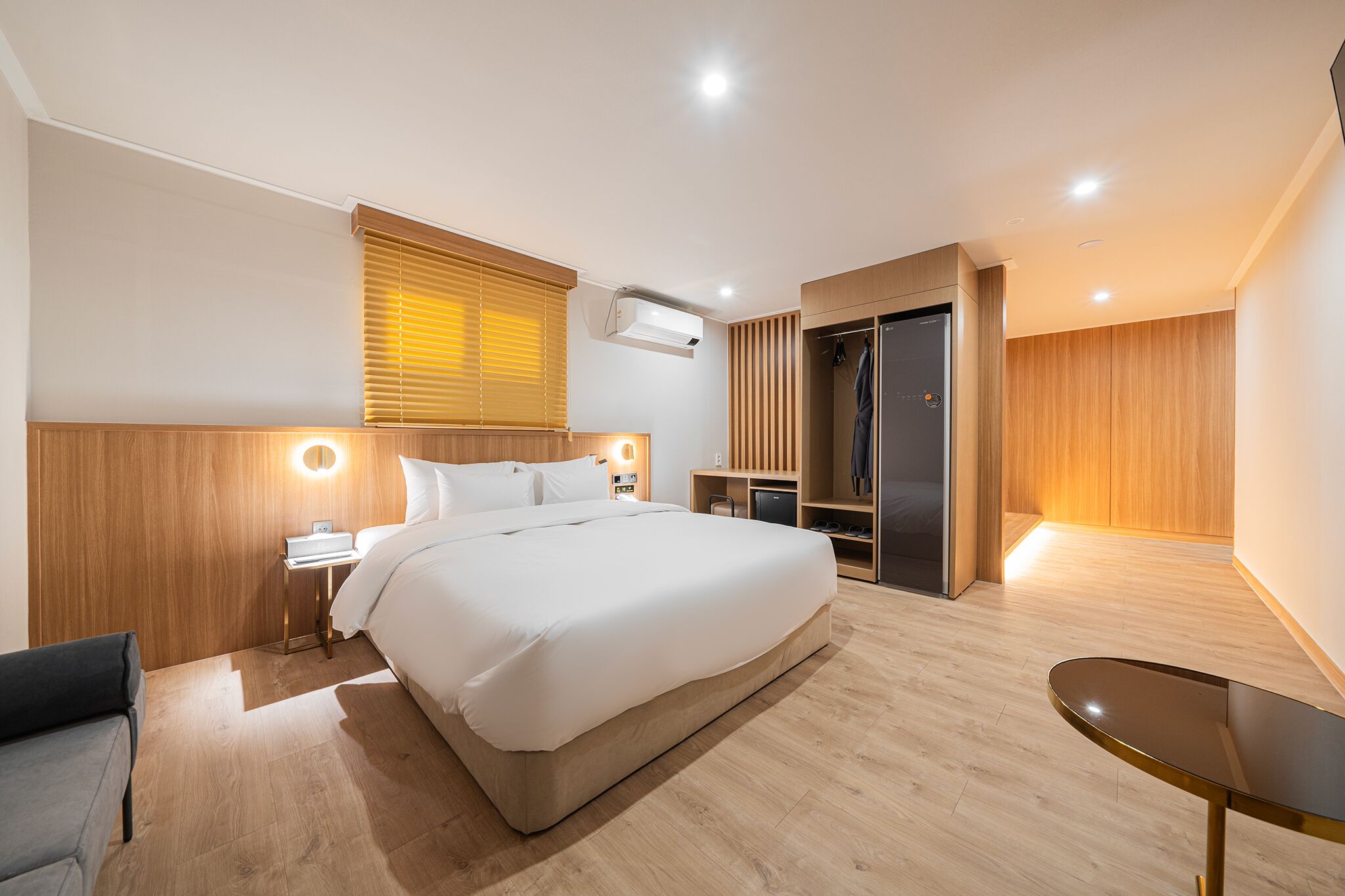 Una habitación de hotel moderna con una cama grande, mesitas de noche, un escritorio y un armario.