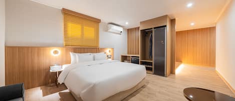Una habitación de hotel moderna con una cama grande, mesitas de noche, un escritorio y un armario.