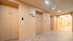 A modern elevator with directional signs and a digital display. - Cheonan H-Avenue Cheonan Buldang (Cheonan)