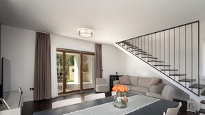 A modern living room with a dining table, sofa, and staircase. - Villa Casa Minerva in Istria for 6 guests, panoramic view, near Porec (Višnjan)