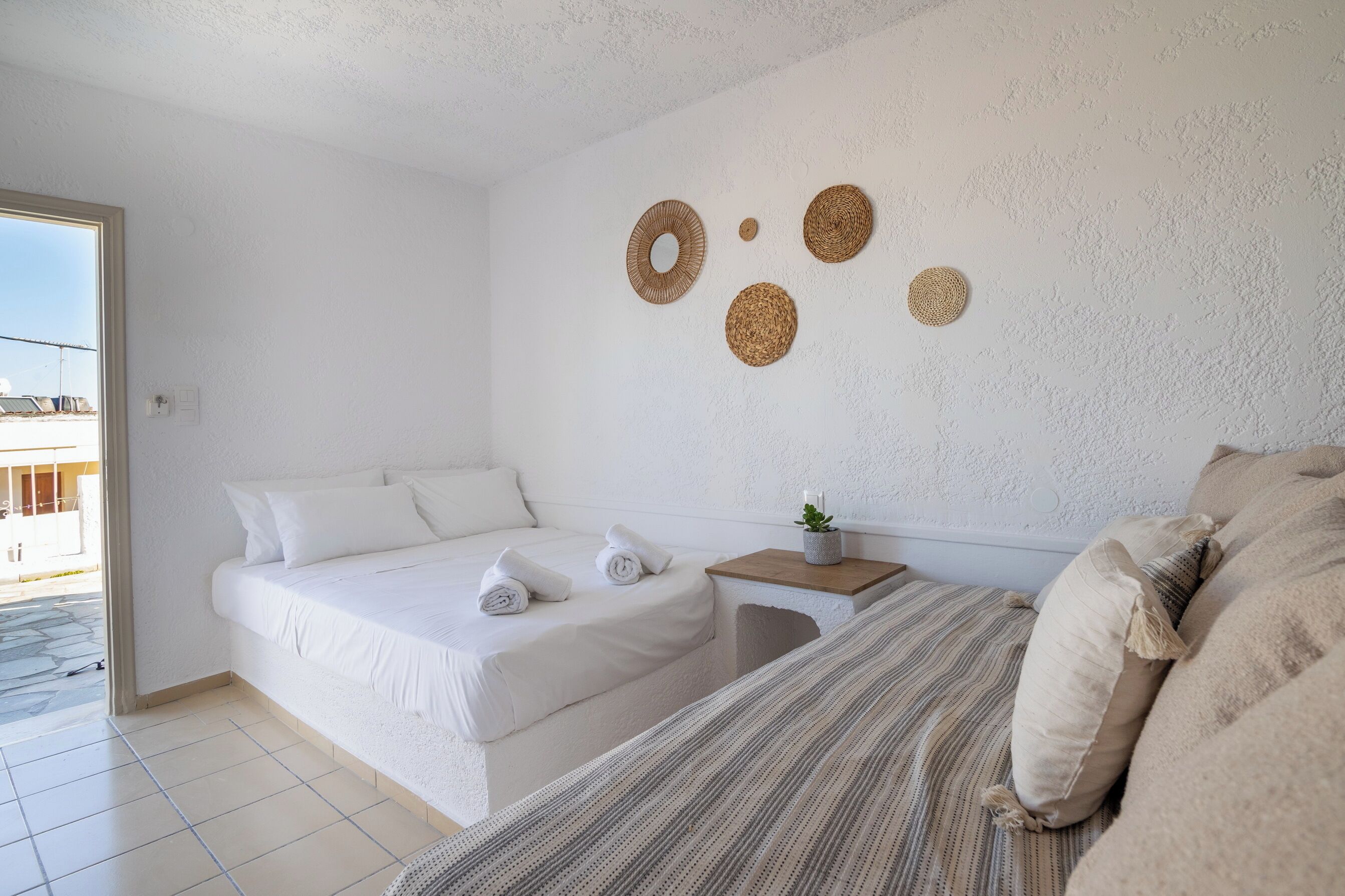 Ein Schlafzimmer mit einem Bett, einem Nachttisch mit Pflanze und einer Wand mit Wandteppich.