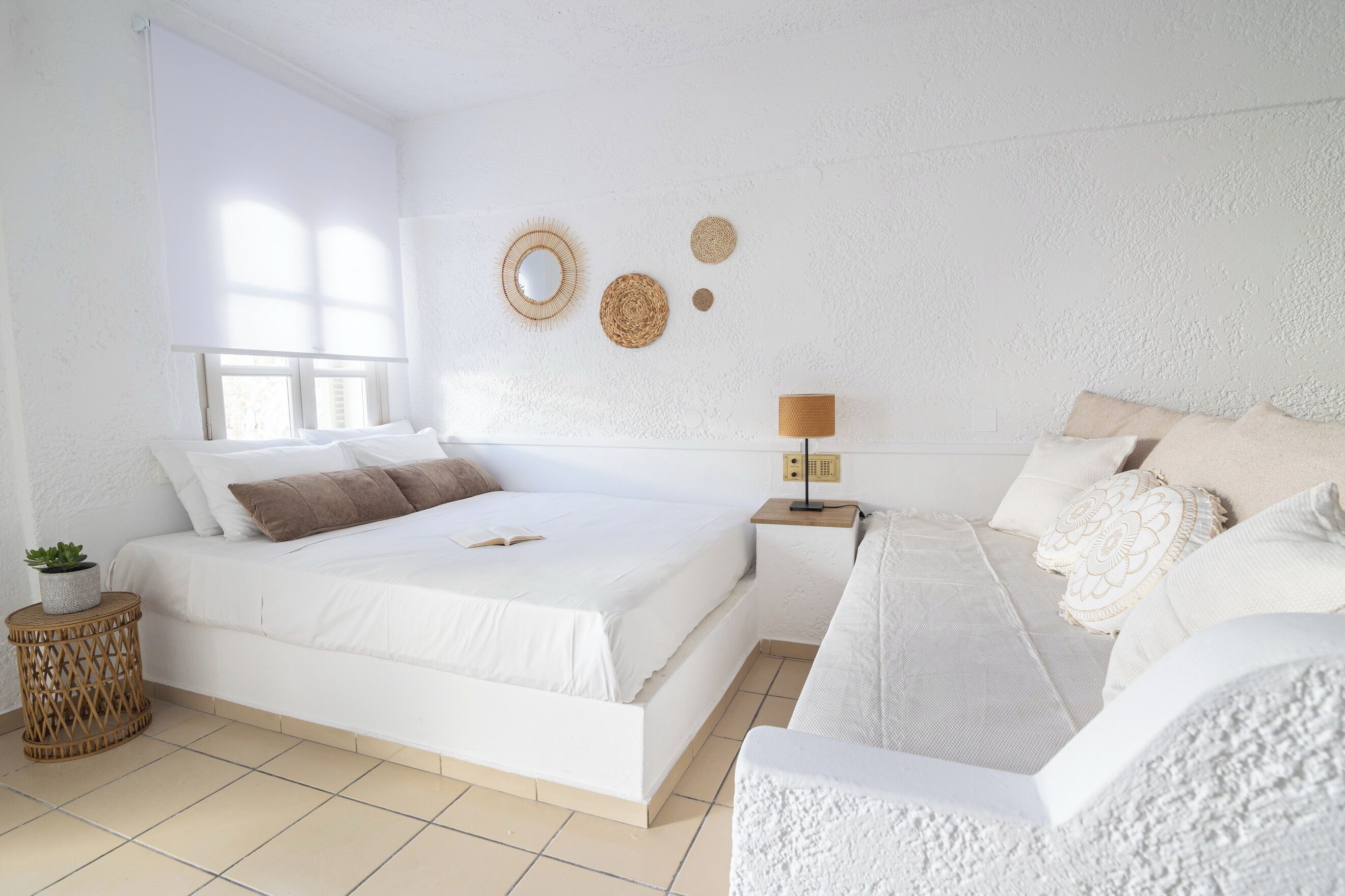 Een slaapkamer met een groot bed, nachtkastjes, een lamp en decoratieve wandelementen.