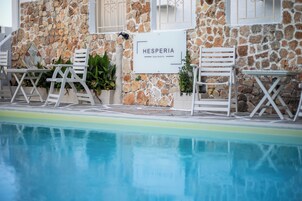 Una piscina al aire libre, sillones reclinables de piscina