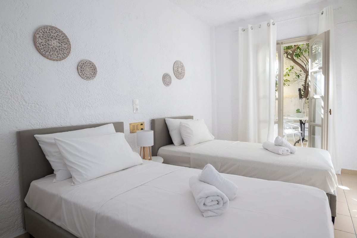 A hotel room with two beds, white bedding, and decorative wall art.