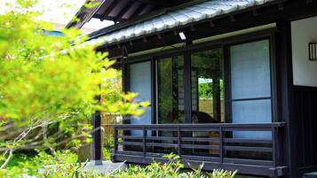 Un edificio japonés tradicional con amplias puertas correderas, un porche de madera y un techo de tejas.