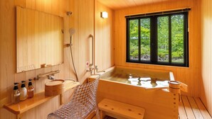 A wooden cabin bathroom with a large window, a bathtub, a shower, and a bench. - Shinshu Omachi Onsen Ryoan Kawaki (Omachi)