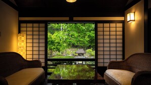 A traditional Japanese room with tatami flooring, a low table, and two tatami mats. - Shinshu Omachi Onsen Ryoan Kawaki (Omachi)