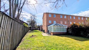 Un quartier résidentiel avec un immeuble en briques, une clôture en bois et une véranda.