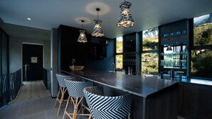 A modern kitchen with a central island, bar stools, and pendant lighting. - Tarentaal Kloof Villa in Higgovale (Cape Town)