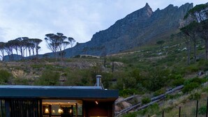 A modern outdoor hot tub area with seating and a bar, surrounded by natural landscape and mountains. - Tarentaal Kloof Villa in Higgovale (Cape Town)