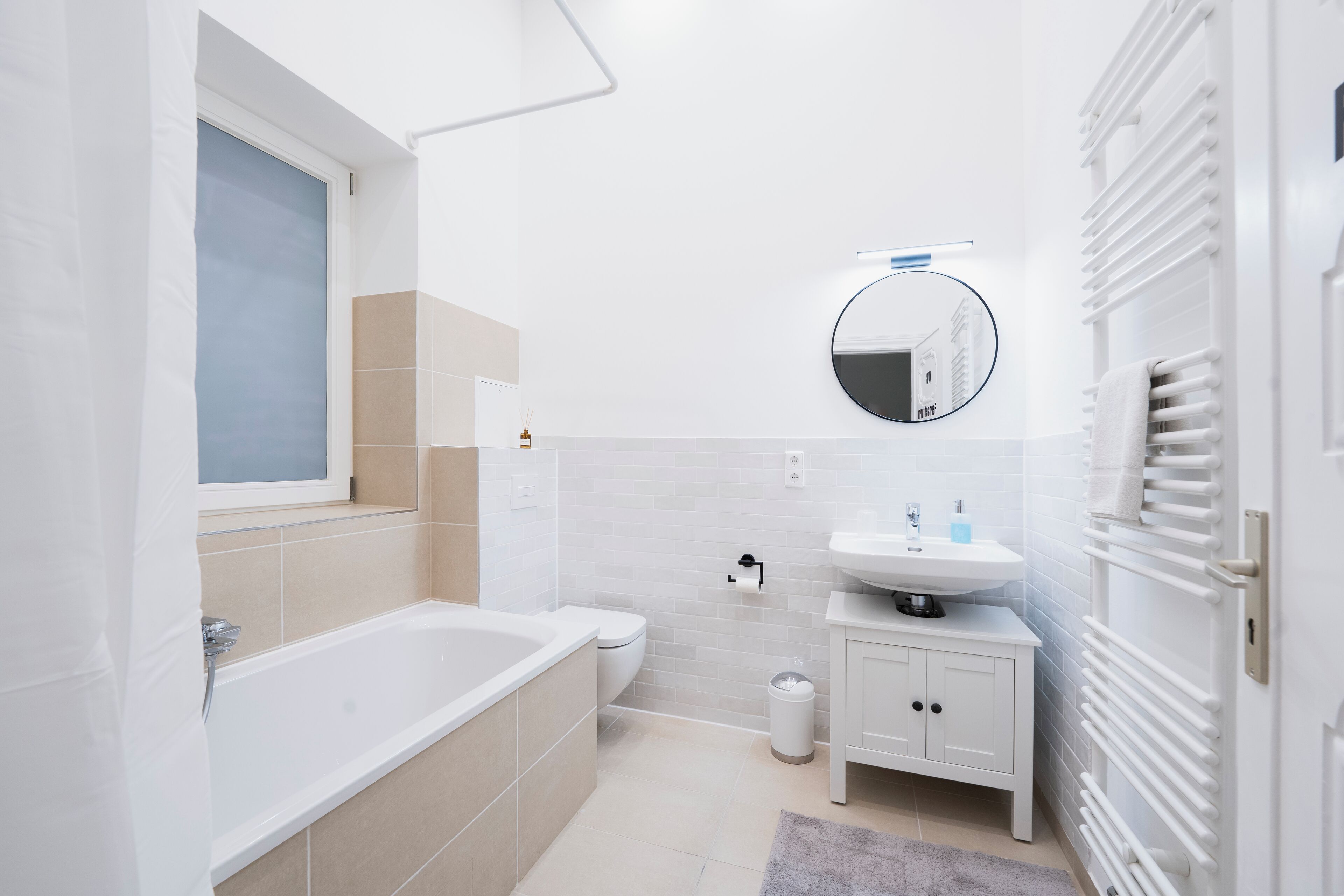 Une salle de bain moderne équipée d’une baignoire, de toilettes, d’un lavabo et d’un miroir.