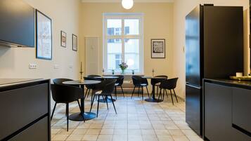 Una cocina moderna con una isla central, electrodomésticos negros y suelo de baldosas.