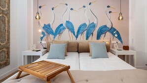 A modern bedroom with a large bed, two bedside tables, and a wooden bench.