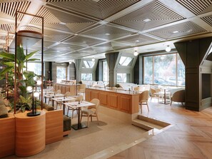 A modern interior with a high ceiling, wooden furniture, and large windows. - Mövenpick Hotel Bari (Bari)