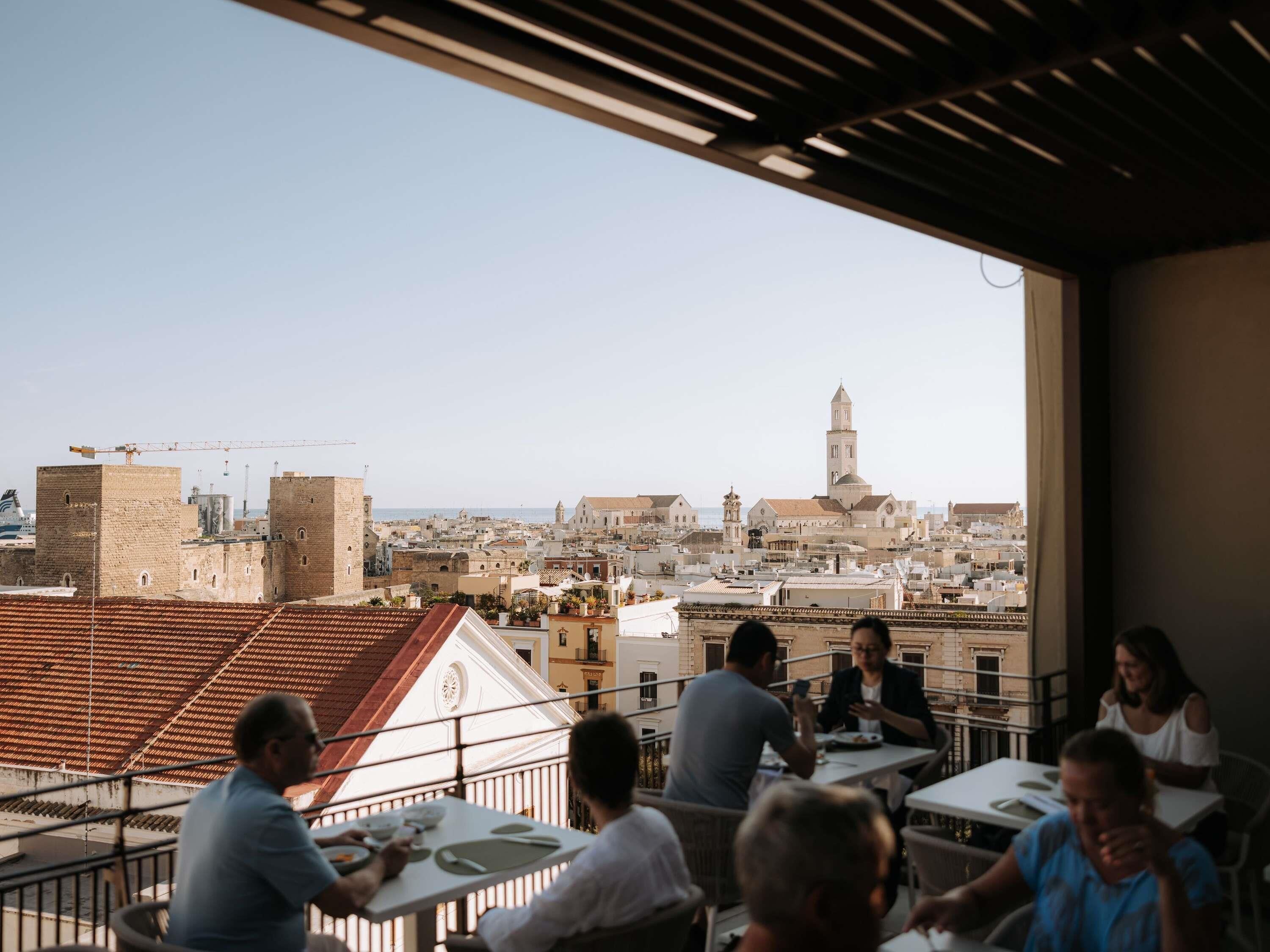 A rooftop terrace with a view of a cityscape, including a prominent tower.