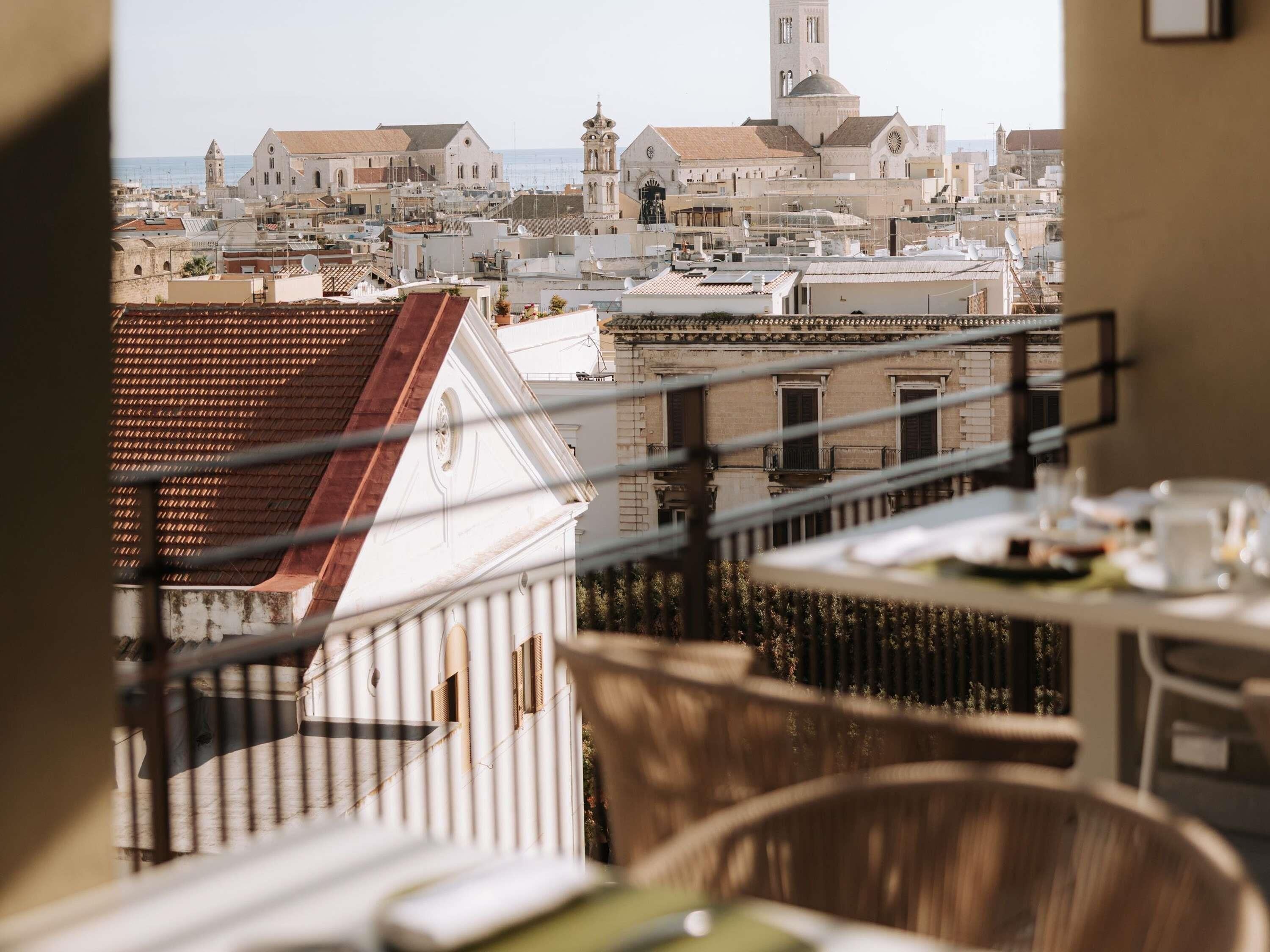 Un balcone con vista sulla città, tra cui edifici e una torre.
