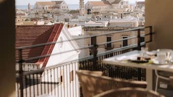 Un balcone con vista sulla città, tra cui edifici e una torre.