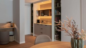 Um interior moderno com uma mesa de jantar de madeira, uma cadeira, uma estante e um vaso com plantas secas.