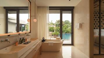 A modern bathroom with a large mirror, a bathtub, and a vanity with a sink.
