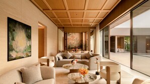A modern interior with a sofa set, a coffee table, and a large painting on the wall. - Raffles Sentosa Singapore (Singapore)