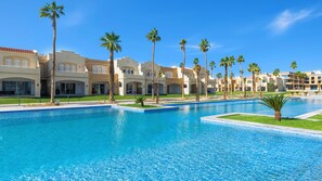 A resort with multiple swimming pools, palm trees, and Mediterranean-style buildings. - Rixos Obhur Jeddah Resort & Villas (Jeddah)